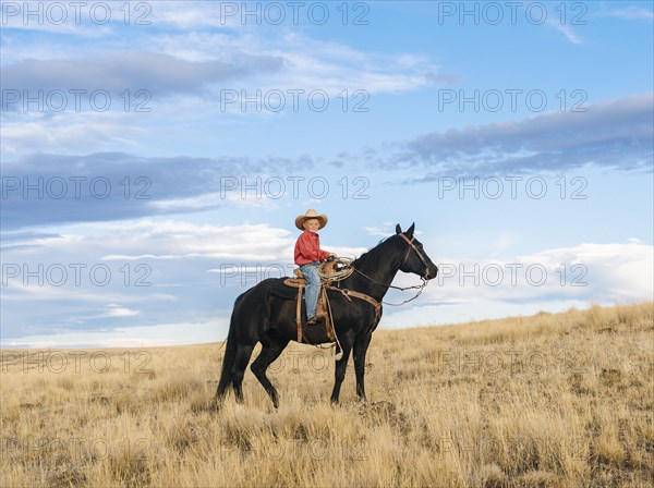 Caucasian boy on horseback on grassy hill