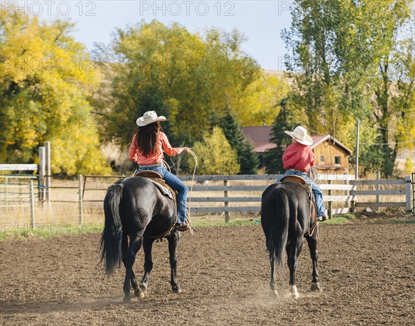 Caucasian mother and son riding horses on ranch