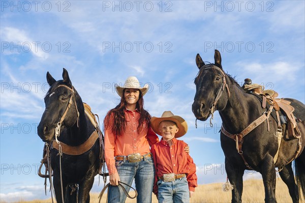 Caucasian mother and son with horses