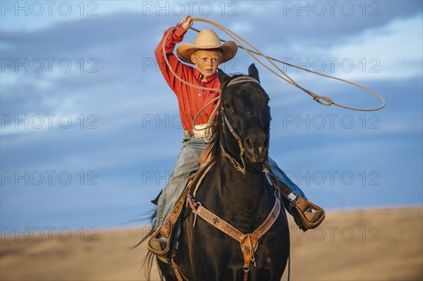 Caucasian boy on horse throwing lasso
