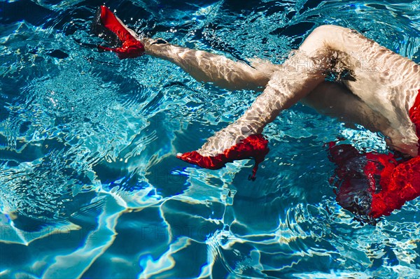 Legs of woman wearing high heels in swimming pool