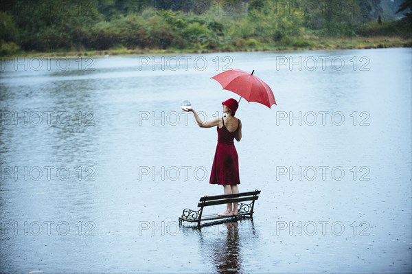 Caucasian woman standing on bench in flood