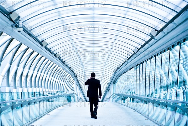 Caucasian businessman talking on cell phone in tunnel