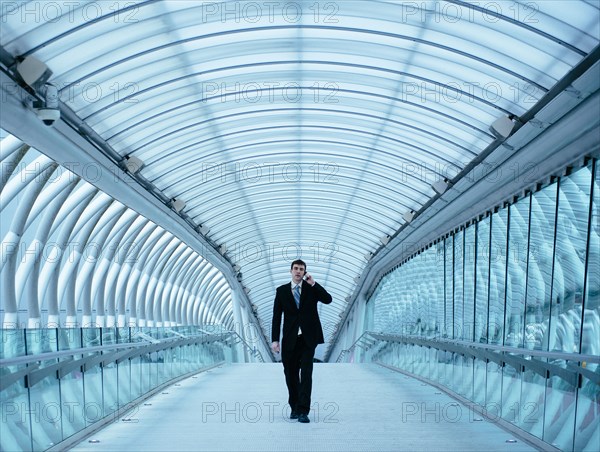 Caucasian businessman talking on cell phone in tunnel