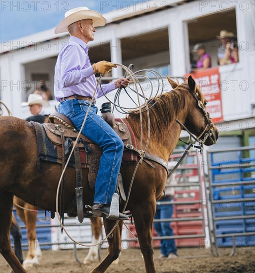 Caucasian cowboy riding horse in rodeo