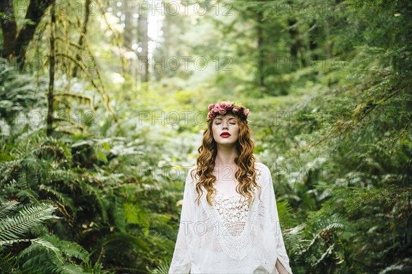 Caucasian woman wearing flower crown in forest