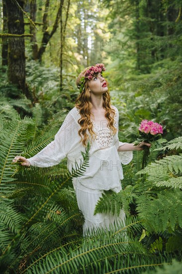 Caucasian woman wearing flower crown in forest