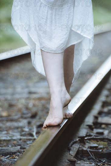 Caucasian woman balancing on train tracks