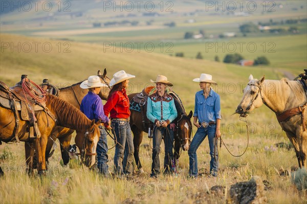 Cowboy and cowgirls with horses on ranch