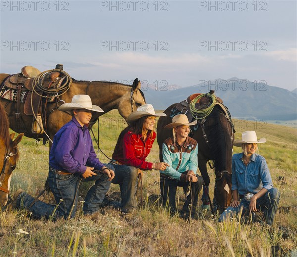 Cowboy and cowgirls with horses on ranch