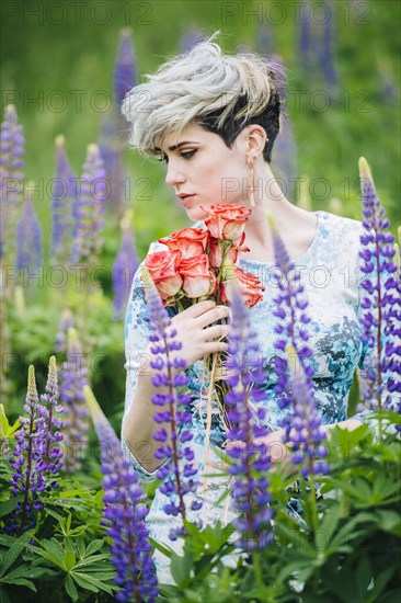 Caucasian woman holding bouquet in field of flowers