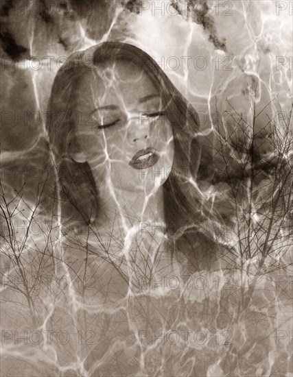 Multiple exposure of Caucasian woman and barren trees