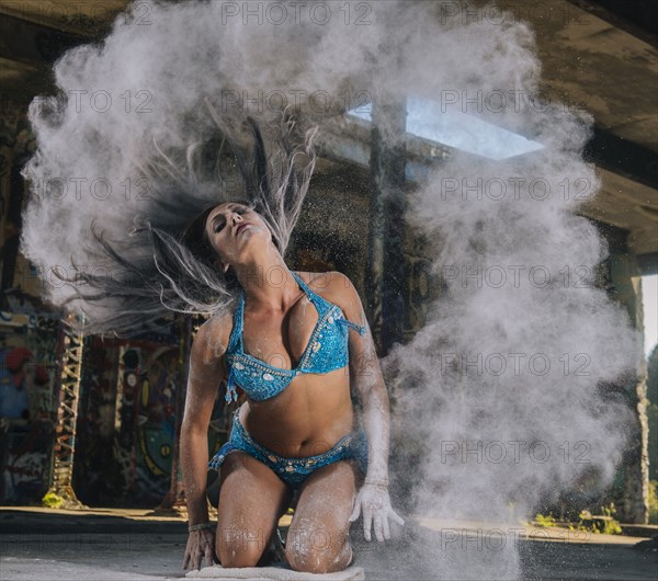 Belly dancer tossing hair with powder