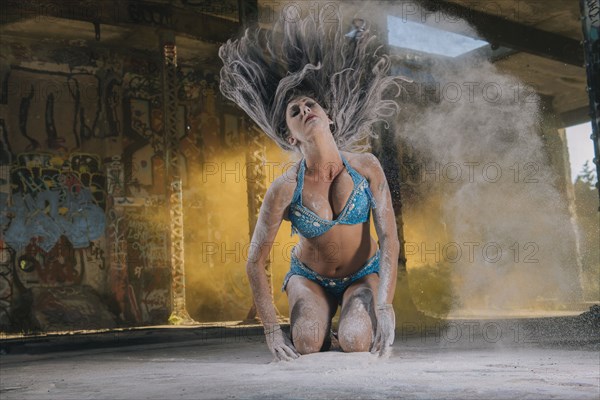 Belly dancer tossing hair with powder