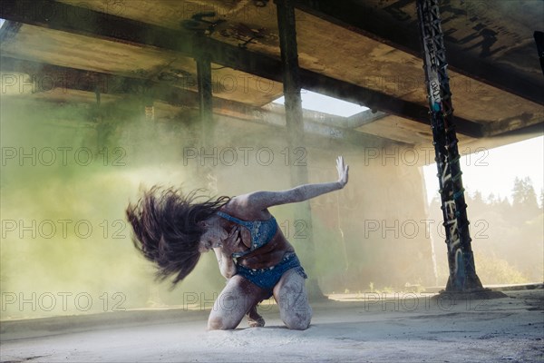 Belly dancer kneeling in powder