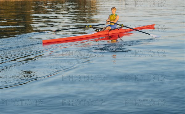 Caucasian man rowing on lake