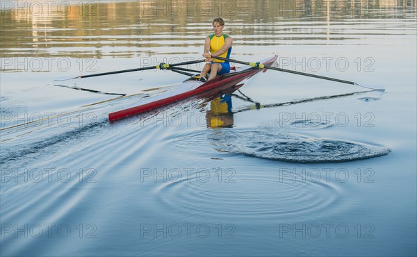 Caucasian man rowing on lake