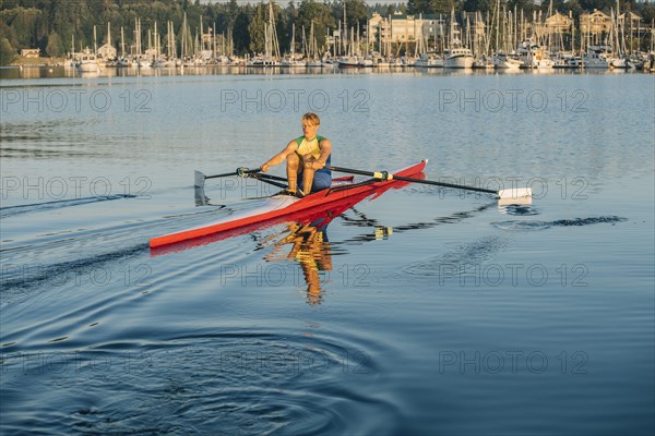 Caucasian man rowing on lake