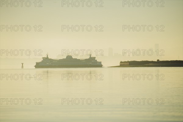 Cruise ship near city skyline at sunset