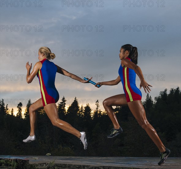 Runners passing baton in race