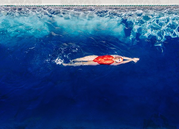 Caucasian woman swimming in swimming pool