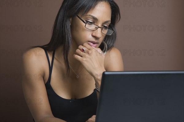 Mixed Race woman looking at laptop