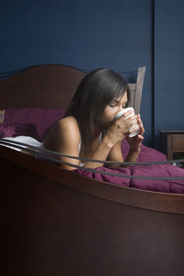 Mixed Race woman drinking coffee