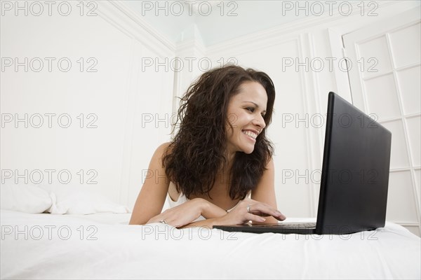 Hispanic woman looking at laptop