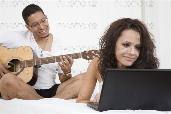 Hispanic couple relaxing on bed