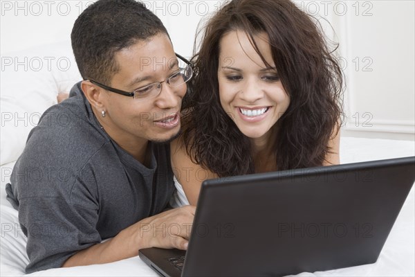 Hispanic couple looking at laptop