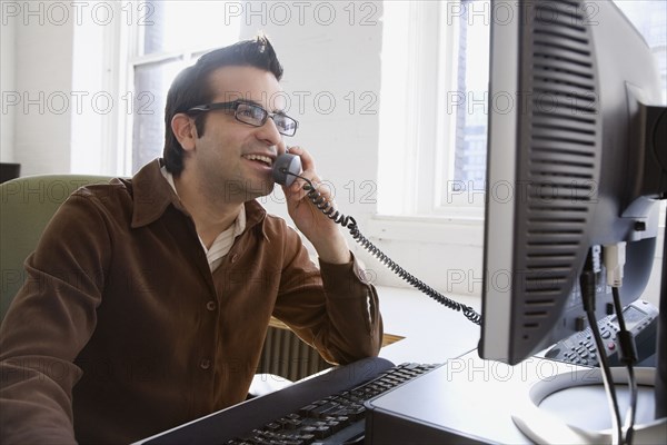 Hispanic businessman talking on telephone