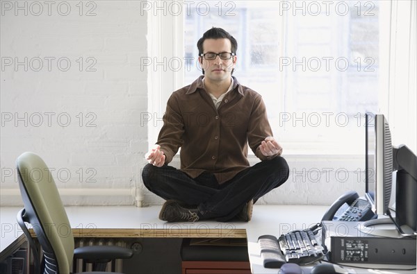 Hispanic businessman meditating