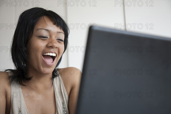 Grinning woman looking at laptop