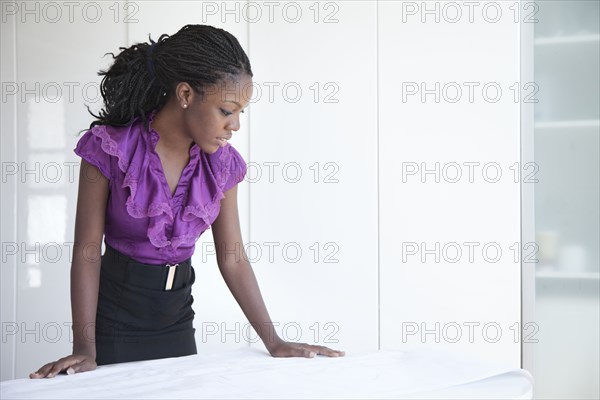 Black businesswoman reviewing blueprints