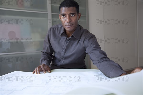 Black businessman reviewing blueprints