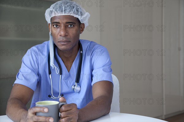 Black doctor in scrubs and surgical cap