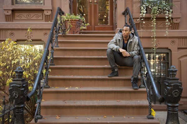 Black man sitting on front stoop