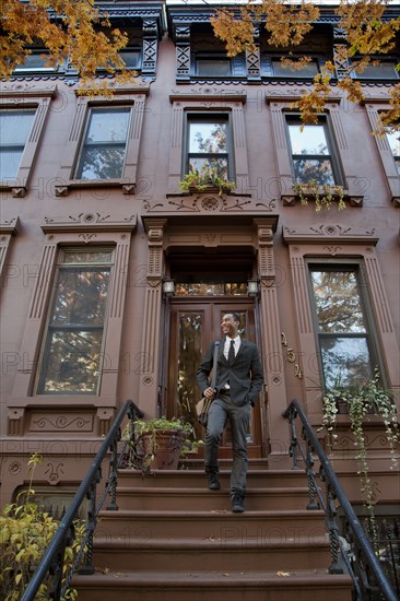 Black businessman walking down front stoop steps