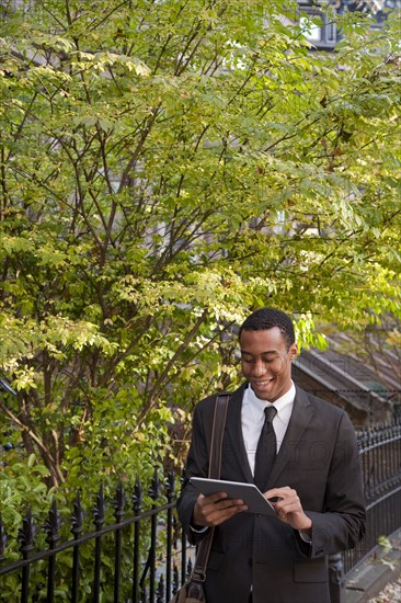 Black businessman using digital tablet outdoors