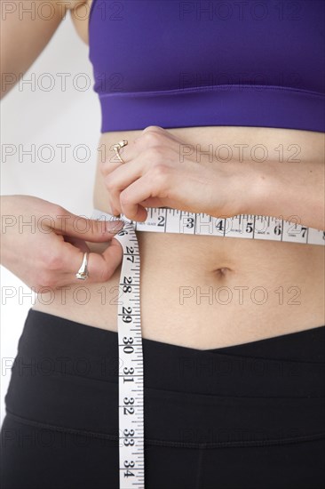 Woman measuring waistline