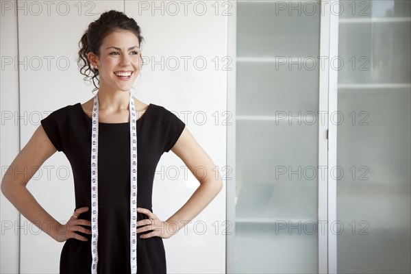 Businesswoman with measuring tape around her neck