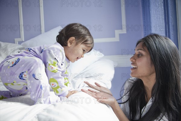 Sri Lankan mother taking baby girl off bed