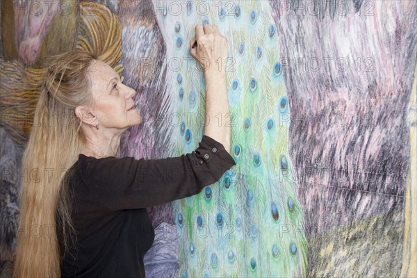 Caucasian woman drawing mural on wall