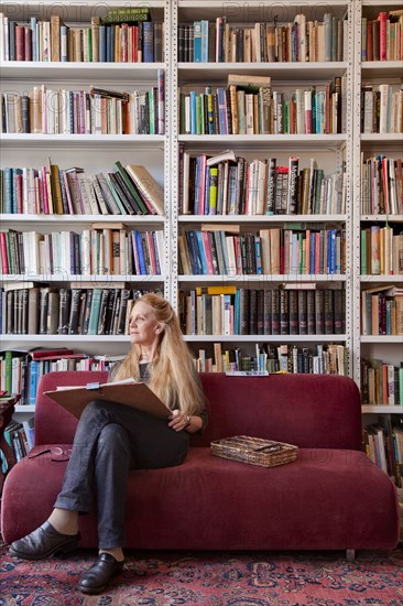 Caucasian woman sitting on sofa sketching