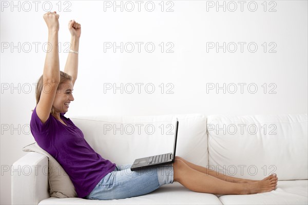 Caucasian woman using laptop on sofa