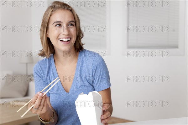 Caucasian woman eating Chinese food