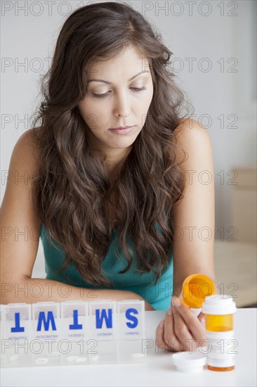 Mixed race woman organizing pills