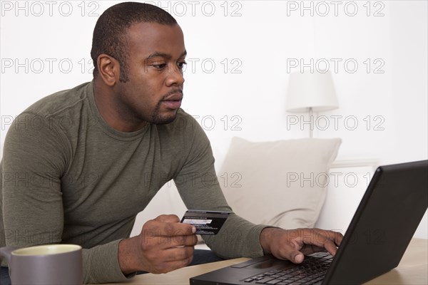 Black man shopping online with credit card