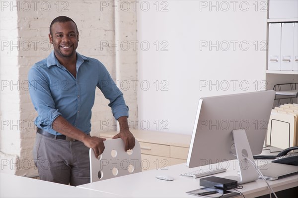 Black businessman standing at desk in office