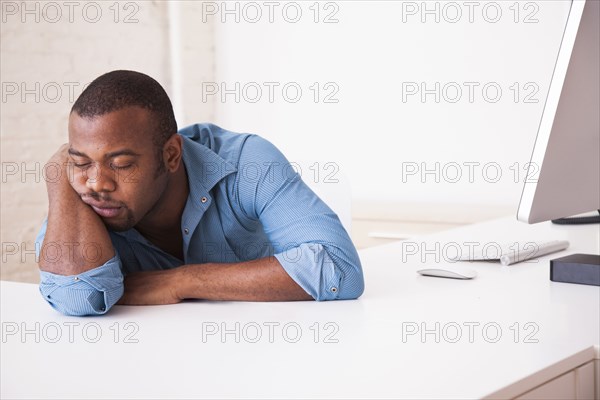 Black businessman sleeping at desk